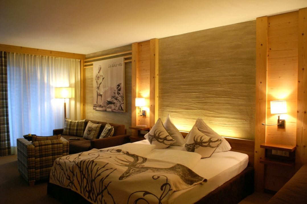 Doppelbett und Sofa der Gartensuite im Andreus Golf & Wellness Resort Hotel