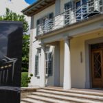 Logo-Säule im Garten der Villa Aurum