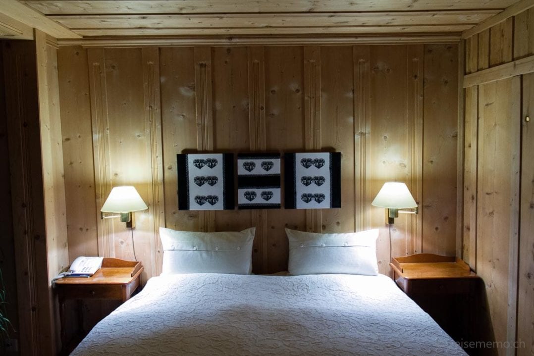 Doppelbett in der Hostellerie Alpenrose mit Scherenschnitt-Dekoration