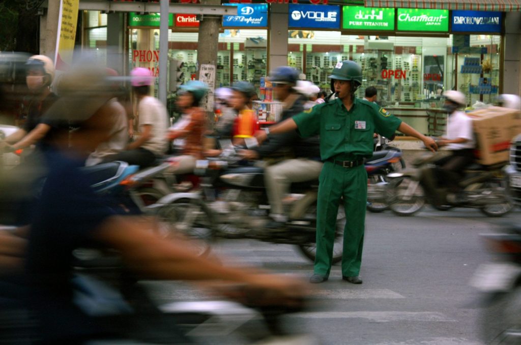 Junger Verkehrspolizist im dichten Verkehr von Saigon