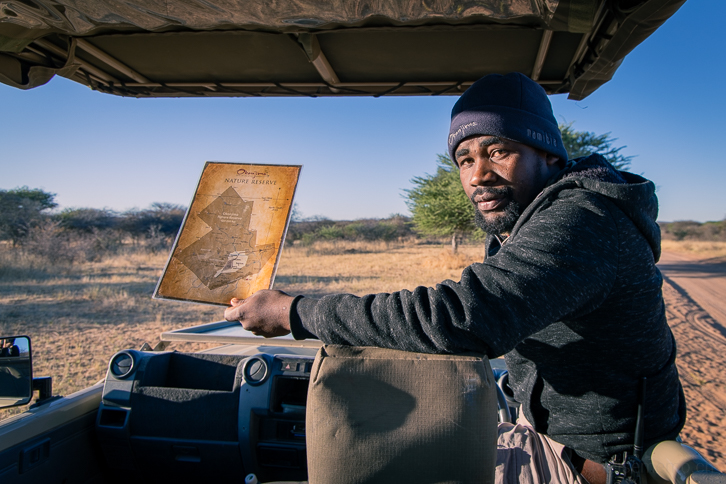 Ranger Opari mit der Karte des Okonjima Naturreservats in Namibia