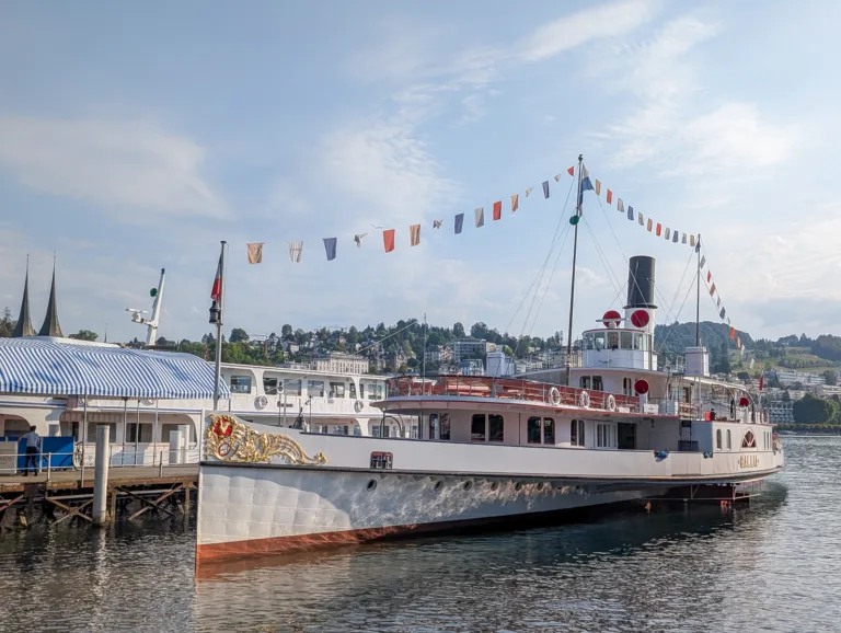 Das historische Dampfschiff Gallia mit bunten Signalflaggen liegt am Steg in Luzern am Vierwaldstättersee