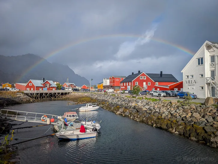 Regenbogen über roten Rorbuer Fischerhütten in Henningsvær