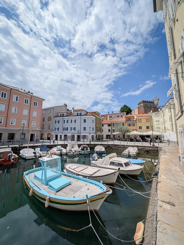 Was tun rund um Triest: Vom Märchenschloss, Tropfsteinhöhlen und Slowenien 5 Boote im Fischerhafen von Muggia