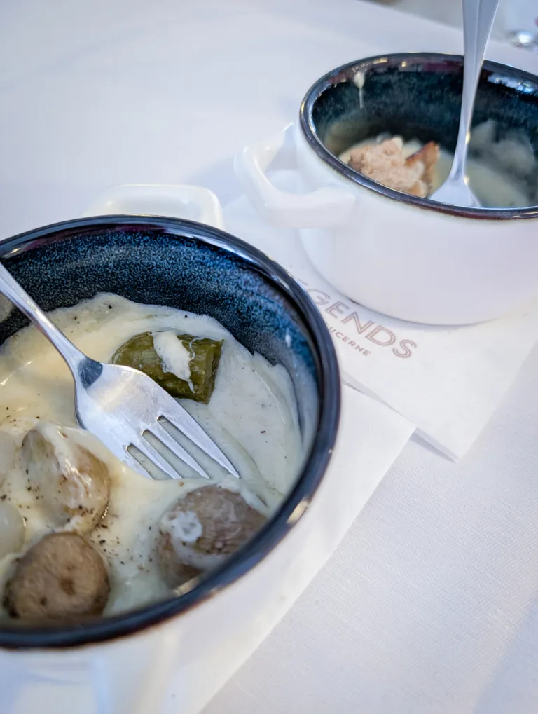Zwei kleine Schalen mit regionalem Eintopf und cremiger Sauce auf weissem Tuchserviette