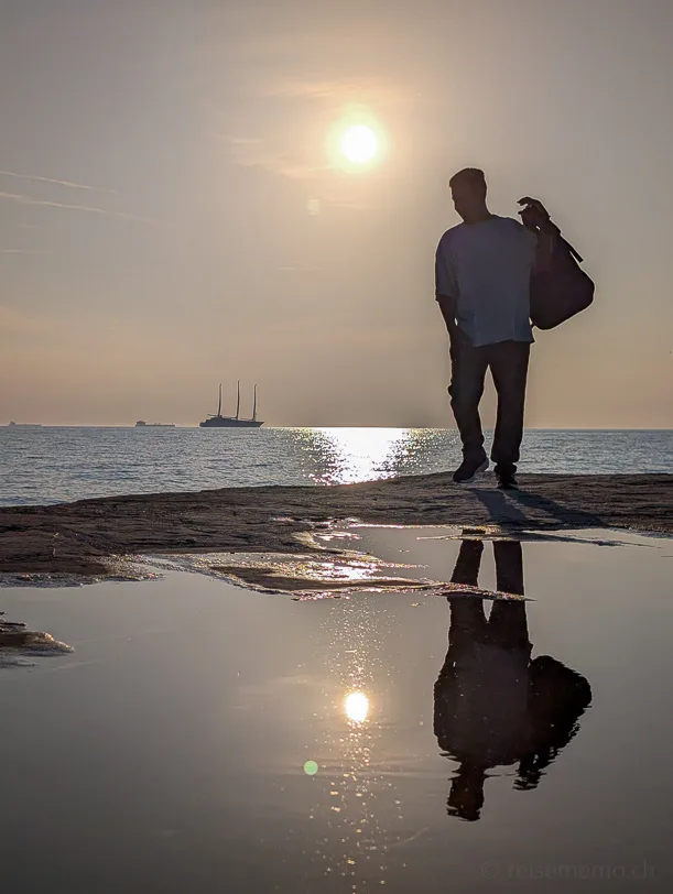 Was tun in Triest - der Kaffeehauptstadt Italiens 5 Tourist auf dem Pier Molo Audace in Triest im Sonnenuntergang